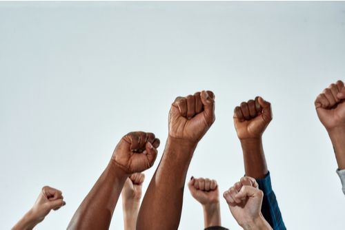 mãos-de-diferentes-raças-levantadas-lutando-pelos-direitos-do-homem-e-do-cidadão